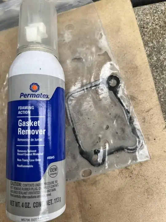 metal gasket soaking in gasket remover to refurbish it
