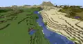 A large river separating a desert and a forest.
