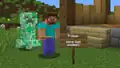 A creeper sneaks up behind Steve.