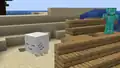 A ghastling next to a player in a beach