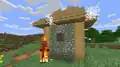 A screenshot of an abandoned house with a burning zombie in front of it.