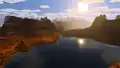 A lake in a badlands biome, with a wooded badlands behind it.