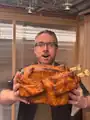 Marc Watson holding the prop of a cooked chicken.