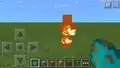 A burning zombie in Bedrock Edition, emitting particles with fire's animation.