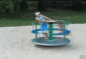 A child in orange flying off of a merry-go-round