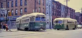 A PCC-type trolley and a Brill trackless trolley of PTC, wearing the company's standard paint scheme of green-and-cream in 1968 at 7th Street & Snyder Avenue.
