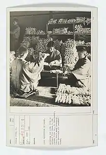 Four men weigh bundles of raw silk in Japan, in September 1918.