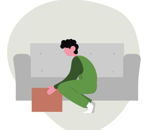 A man moving a box in his living room.